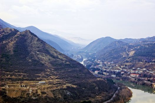 River junction on mountains and sky background