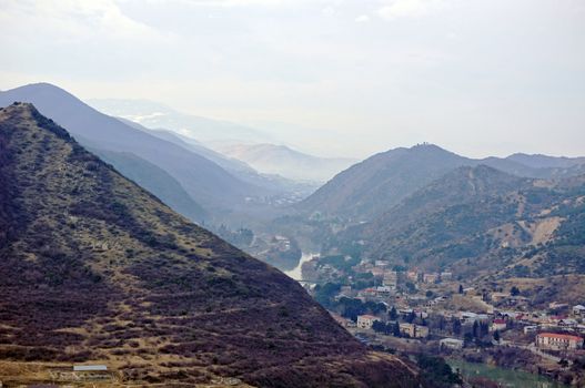 River junction on mountains and sky background