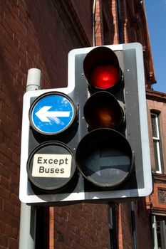 A post with traffic lights and a directional arrow and a sign with the words 'EXCEPT BUSES'.