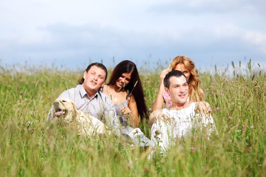 friends and dog in green grass field