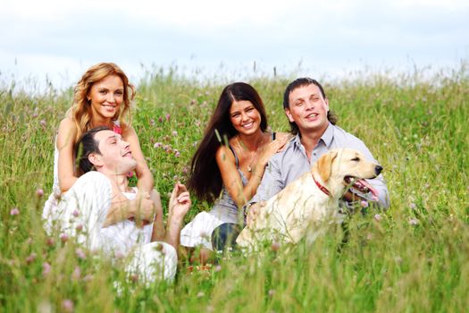 friends and dog in green grass field