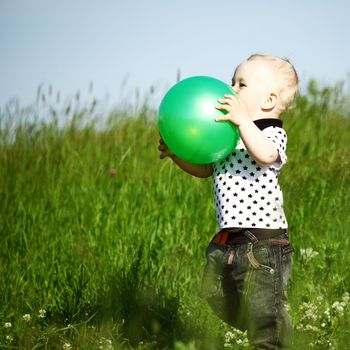  little boy play in green grass with green ball