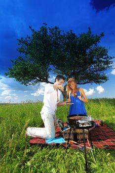 man and woman on picnic in green grass