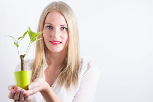 Young woman with small tree smiling happily