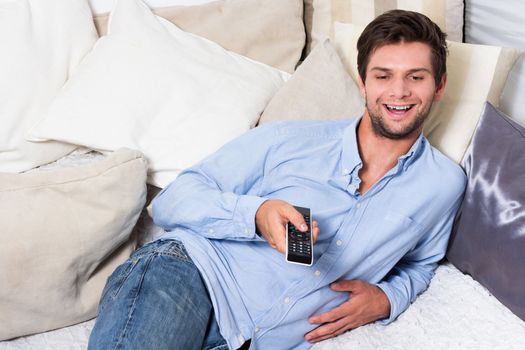 Man in blue shirt and jeans with remote control