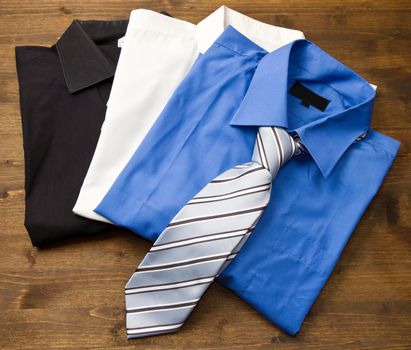 Close up of stacked shirts with tie on wood
