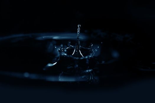 Extremely macro photo of the liquid splashing with light reflections