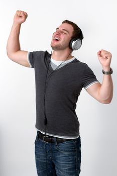 Young Man Listening to music and dancing with arms in air