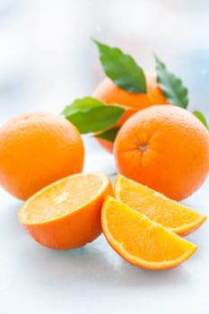 Sliced and whole orange with green leaves