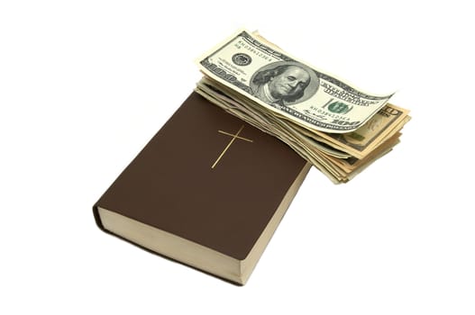 book of the Bible and dollars on white background