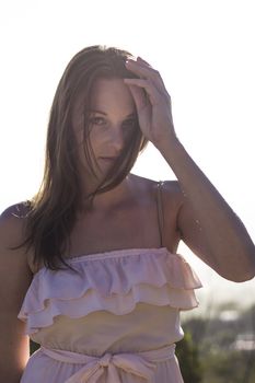 Wind blowing through Hair of brunette female model standing in the sun