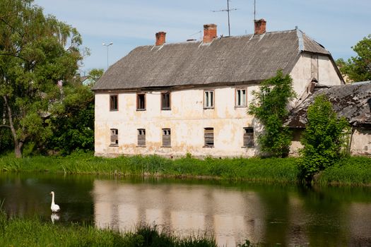 old abandoned house near river with broken windows