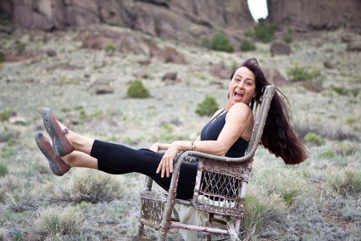 Beautiful Woman sitting out in Nature in a old Rocking Chair