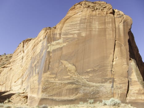 tall sandstone cliff with a bright blue sky in southern Utah