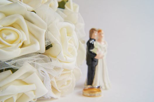 Wedding decoration - white roses bouquet, rings, bride and groom