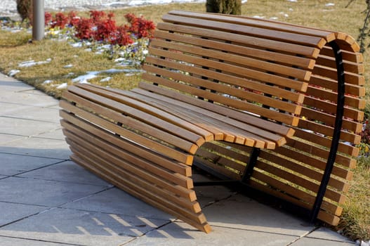 Wooden park bench in a sunny day - winter time