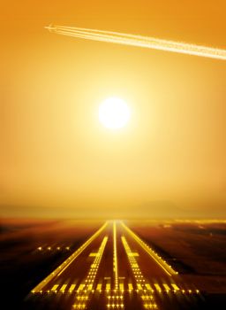 passenger plane fly up over runway from airport at sunset