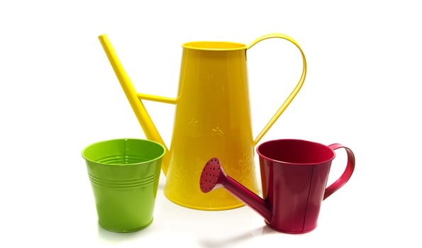 yellow and pink watering can and green pot