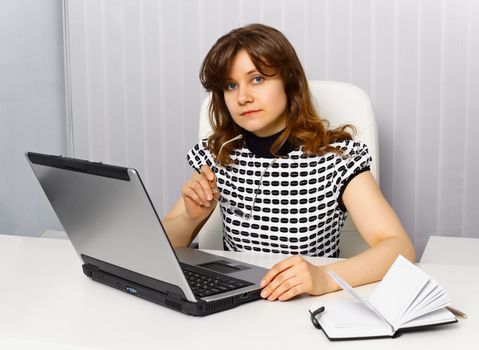 Young businesswoman sitting at a desk in office