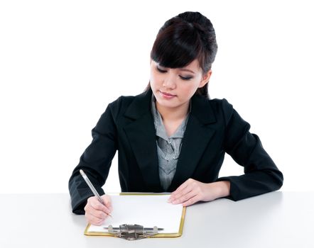 Portrait of a cute young Asian businesswoman writng on clipboard against white background.