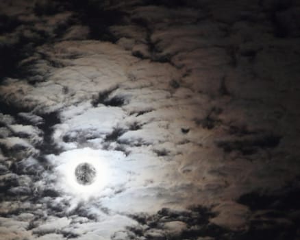 Lights on the photo of the Moon in the night cloudy sky