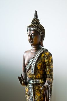 Buddha statue with a golden robe with a white grey background