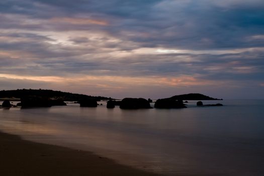 Twilight after a sunset at a beach, with long exposure, rock formation in the water