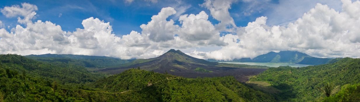 Panoramic view of a volcano mountain surrounded by lakes and green vegetation