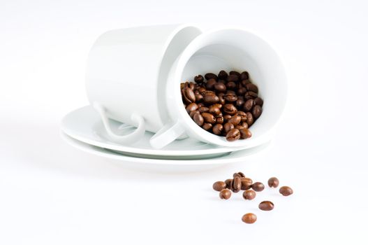 Coffee cups and coffee beans over white