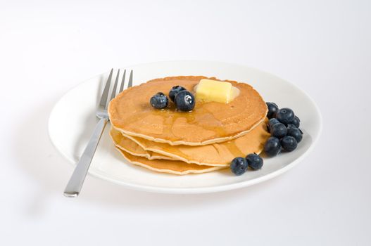 blueberry pancakes on a plate with fork isolated on white 
