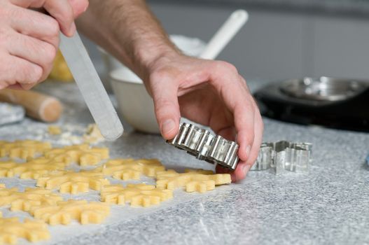 Placing star and heart shape cookies after cutting on backing paper