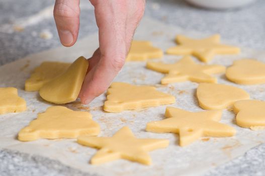 Placing star and heart shape cookies after cutting on backing paper