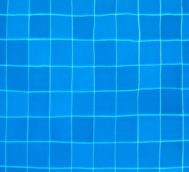 Blue tiles at the bottom of a swimming pool - abstract background