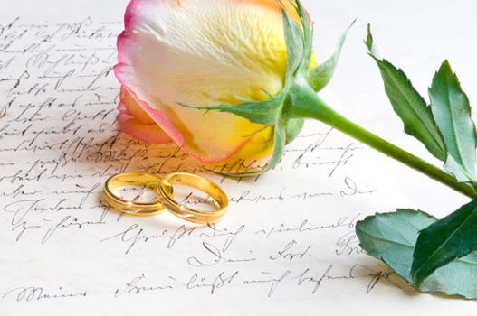 Red yellow rose and ring over a hand written love letter