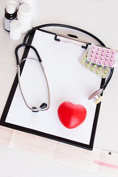 Stethoscope, pills on ecg with heart, medical check concept