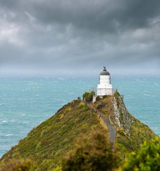 Nugget Point Light House an dark clouds in the sky, Catlins, New Zealand 