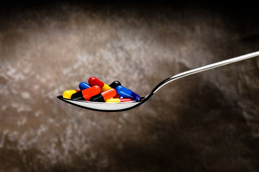 One spoon of medication in front of a grungy background