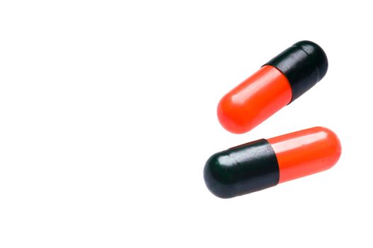 Two black red capsules over white