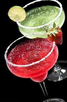 Green and Red Margarita in front of a black background with fresh garnish
