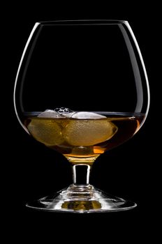 Whisky on the rocks over black in a beautiful glass