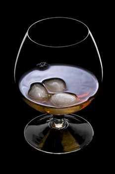 Whisky on the rocks over black in a beautiful glass