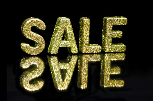 In capital letter written Sale, glitter effect over black