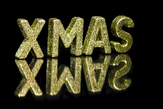 In capital letter written Xmas, glitter effect over black