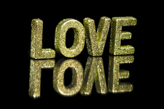 In capital letter written love, glitter effect over black