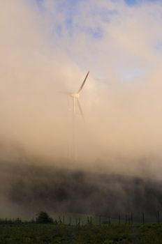 Windmill in the countryside during fog in the evening