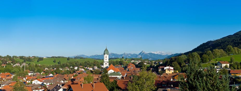 Panoramic view above the roofs of Pfronten im Allgaeu, Alps in the background