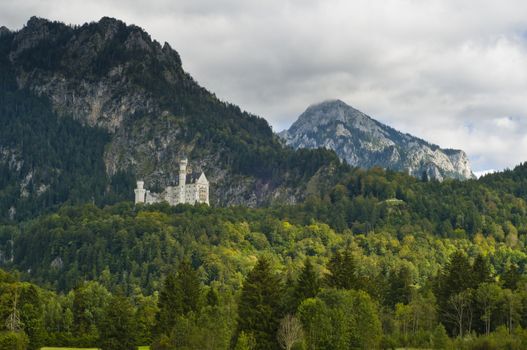 Castle Neuschwanstein with alps in the background in autumn