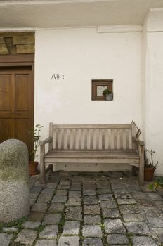 Entrance area to a house with bench nice bright illuminated and cobblestone pavement