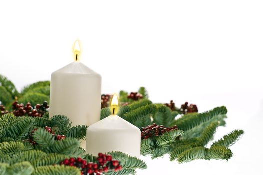 Two candles in advent setting with real Christmas tree branches