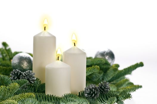 Three candles in advent setting with real Christmas tree branches